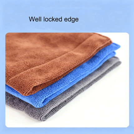 Eliteshine MH-G golf ball towel in three colourways — brown, blue, and grey — stacked and folded showing reinforced locked overlock edge detail on light blue background