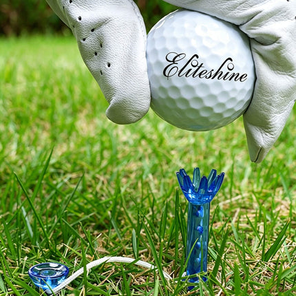 Golfer placing Eliteshine-branded golf ball onto blue T105 magnetic tee in grass with cone retriever tee visible nearby