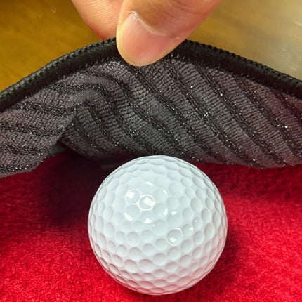 Eliteshine MH-E golf towel diagonal pocket open — showing microfibre inner lining being used to clean a golf ball, with red waffle cotton outer face visible