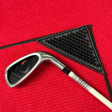 Eliteshine MH-E golf towel triangular rubber scrubbing pad detail — black textured rubber pad with nub surface shown alongside golf iron on red waffle cotton background